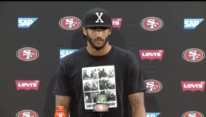 Colin Kaepernick, wearing t-shirt featuring Fidel Castro and Malcolm X. 
