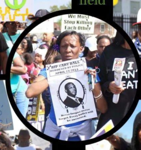 Toni Taylor of the Cary On the Ball Foundation, holding sign demanding justice for her son, Cary Terell Ball Jr. 