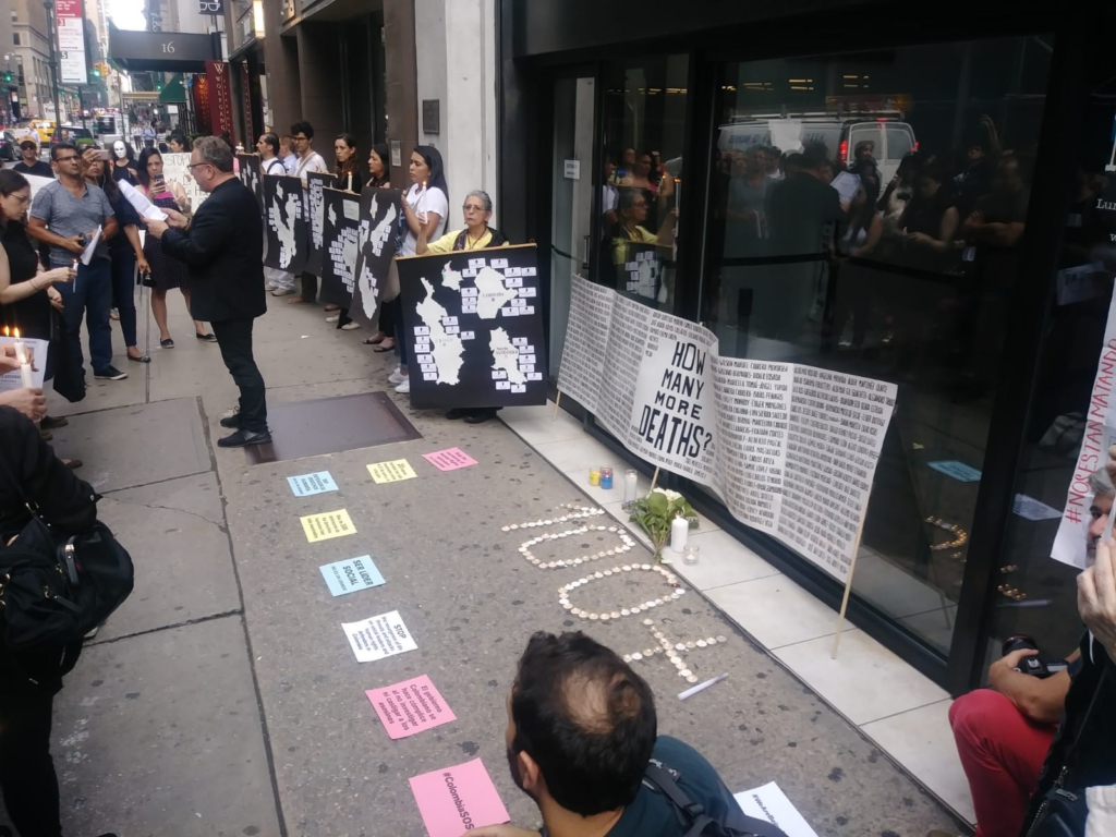 Vigil in New York City. Banner lists the names of those killed by the rightwing. Signs list those killed by region. Photo: Cathy Rojas.