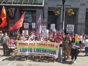 Members of the Party for Socialism and Liberation pose with a banner that reads "Fight for Socialism and LGBTQ Liberation" 