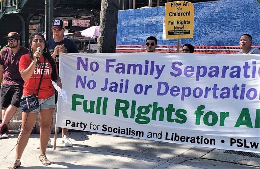 Liberation photo. Activists hold a banner reading: "No family separation! No jail or deportation! Full Rights for All! Party for Socialilsm and Liberation. A woman holds a microphone.