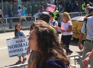 A young child at the "Straight Pride" parade holds a sign that reads "Make normalcy normal again."