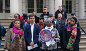 Miembros del Consejo de NYC, flanqueados por activistas, presentan un proyecto de ley en los escalones del Ayuntamiento. 