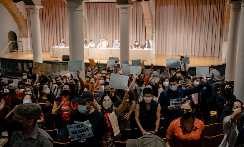 Tenants turn their backs to the board and boo as it votes to increase rent. Liberation photo.