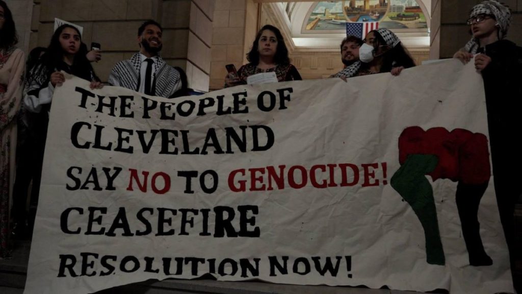 Members of the Cleveland People's Council hold a banner demanding a ceasefire resolution. Liberation photo